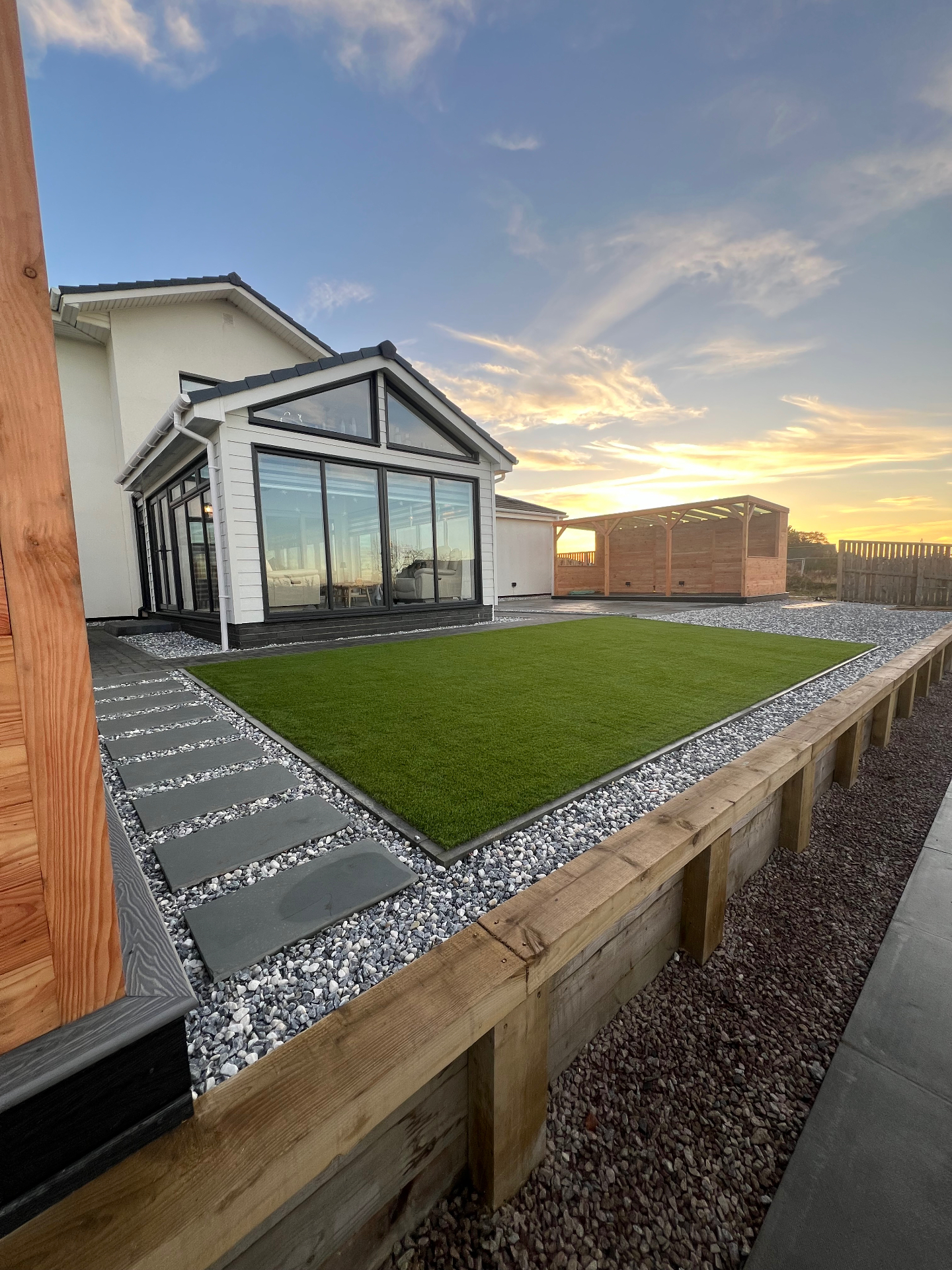 Cedar garden room with porcelain paving at golden hour