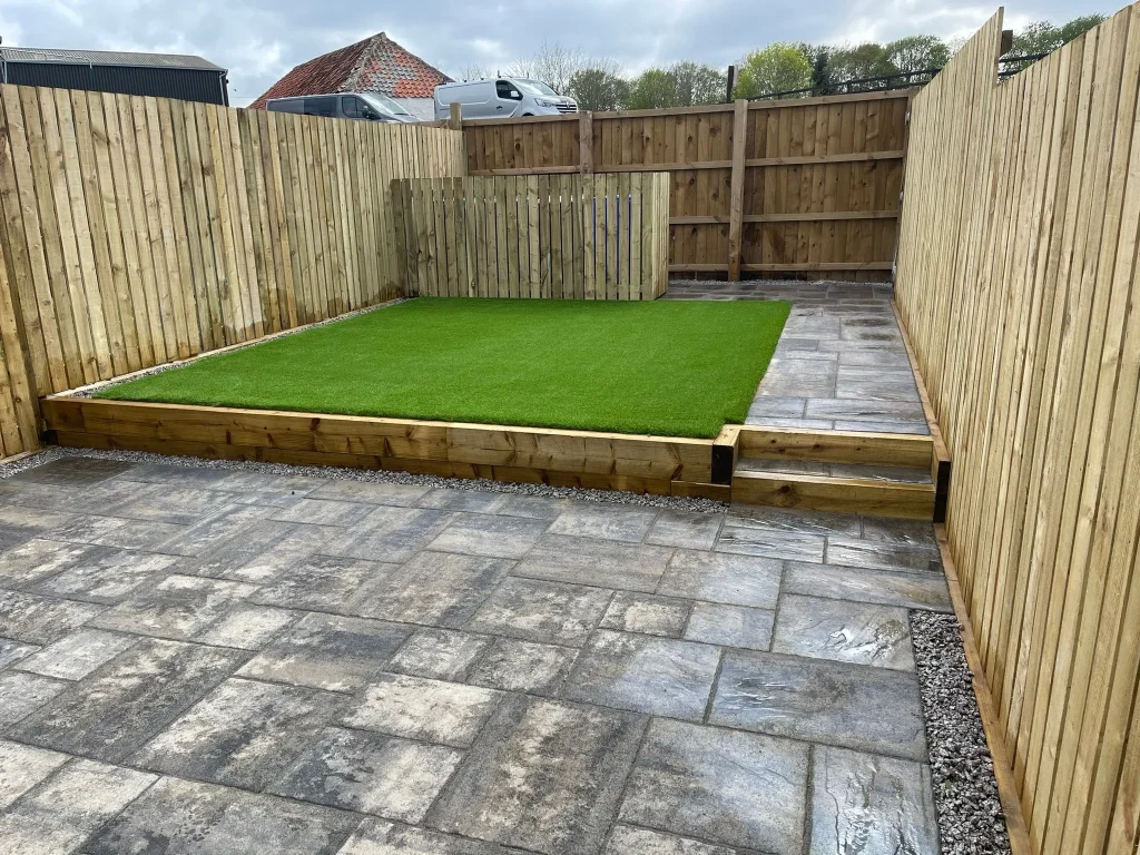 "Experience the beauty and low-maintenance convenience of this stunning garden transformation in Stirling. Our expert team installed artificial grass, a timber fence, and Tobermore Historic Slate to create a space that is both visually appealing and easy to maintain. Enjoy the lush greenery of the artificial grass, the natural charm of the timber fence, and the timeless elegance of the Tobermore Historic Slate, all without the hassle of constant upkeep. Embrace a maintenance-free lifestyle and indulge in the beauty of this meticulously crafted garden."