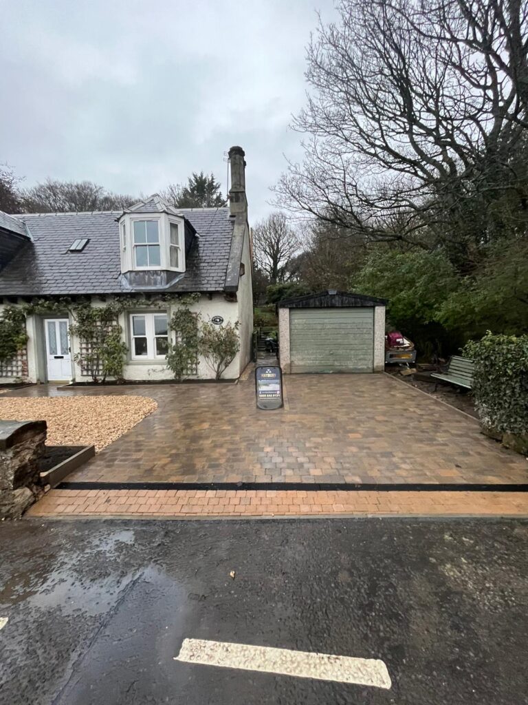 Edinburgh driveway installation using Tobermore Tegula Bracken: A beautifully paved driveway in Edinburgh featuring Tobermore Tegula Bracken pavers. The driveway is meticulously installed with precision, showcasing the elegant and warm tones of the Bracken color. The Tegula pattern adds depth and texture to the overall design, creating a visually appealing and durable surface for vehicles to park on.", Driveway Installation Alloa, Driveway installation Edinburgh