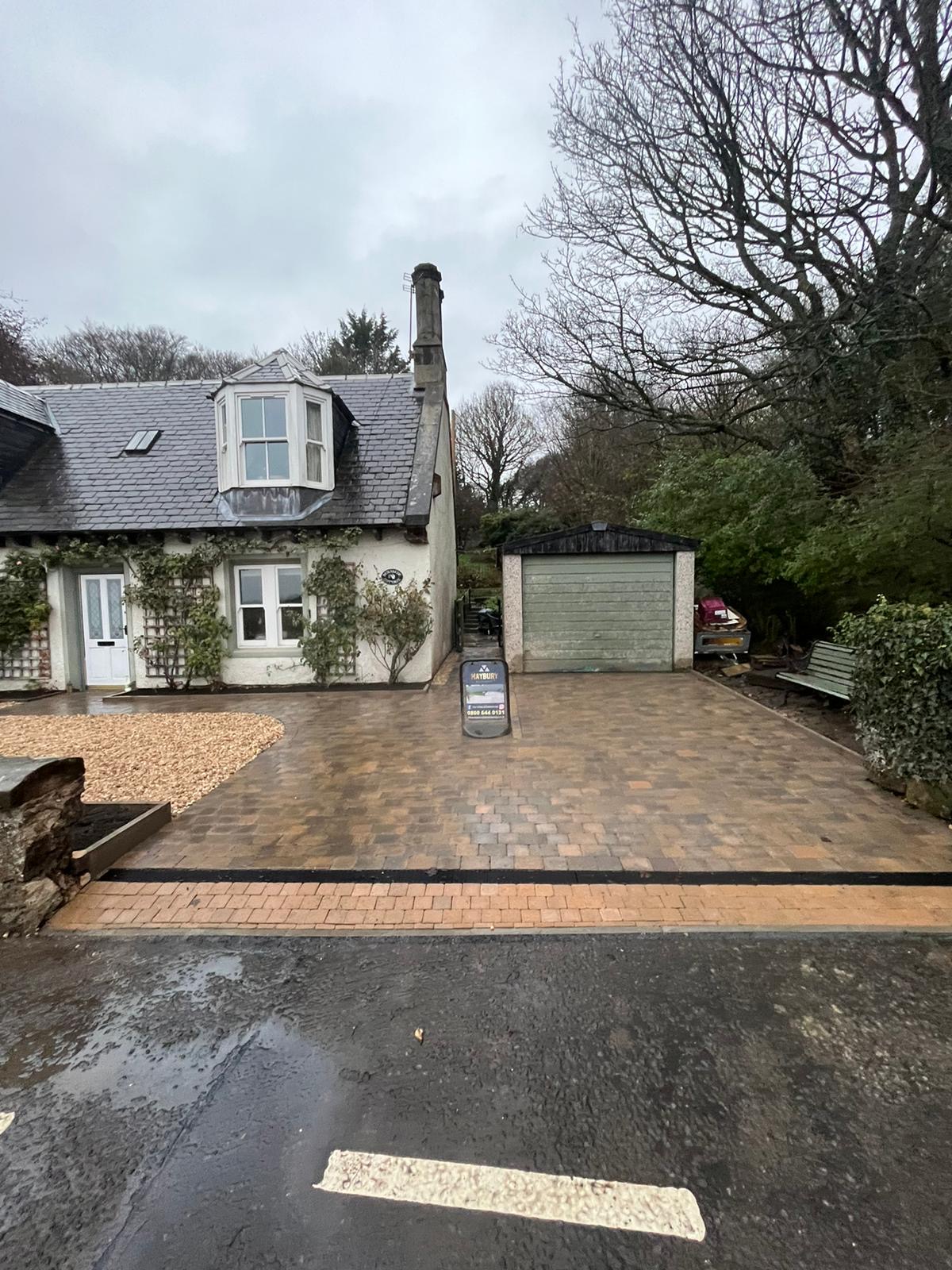 Edinburgh driveway installation using Tobermore Tegula Bracken: A beautifully paved driveway in Edinburgh featuring Tobermore Tegula Bracken pavers. The driveway is meticulously installed with precision, showcasing the elegant and warm tones of the Bracken color. The Tegula pattern adds depth and texture to the overall design, creating a visually appealing and durable surface for vehicles to park on.", Driveway Installation Alloa, Driveway installation Edinburgh
