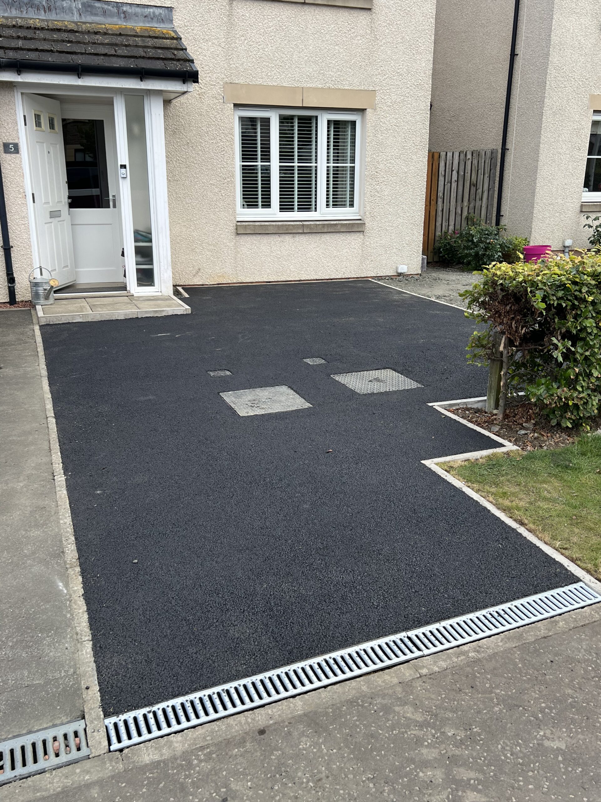 "Maybury installing a tarmac driveway in Falkirk, showcasing the process of ground preparation, laying the tarmac, and compacting the surface for a smooth finish."