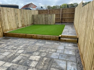 "Escape to tranquility in this maintenance-free garden oasis. Our expertly installed artificial grass, timber fence, and Tobermore Historic Slate combine to create a picture-perfect retreat in Stirling. Sit back, relax, and enjoy the beauty of nature without the hassle of constant upkeep. Experience the best of both worlds - a stunning landscape that requires minimal maintenance. Embrace the serenity and beauty of this meticulously designed garden." "Experience the beauty and low-maintenance convenience of this stunning garden transformation in Stirling. Our expert team installed artificial grass, a timber fence, and Tobermore Historic Slate to create a space that is both visually appealing and easy to maintain. Enjoy the lush greenery of the artificial grass, the natural charm of the timber fence, and the timeless elegance of the Tobermore Historic Slate, all without the hassle of constant upkeep. Embrace a maintenance-free lifestyle and indulge in the beauty of this meticulously crafted garden."