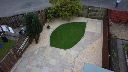 "Transform your outdoor space with this stunning patio installation in Alloa! Our skilled team combined Indian sandstone paving and lush artificial grass, creating a perfect blend of elegance and low maintenance. The finishing touch? Surrounding it all with decorative stones, adding a touch of charm and sophistication. Get inspired and create your own oasis today!" Alt text: A beautifully designed patio installation in Alloa featuring Indian sandstone paving and artificial grass, surrounded by decorative stones. Garden Landscaping Edinburgh, Garden Landscaping Alloa, Patios and Paving Alloa, Patios and Paving Edinburgh