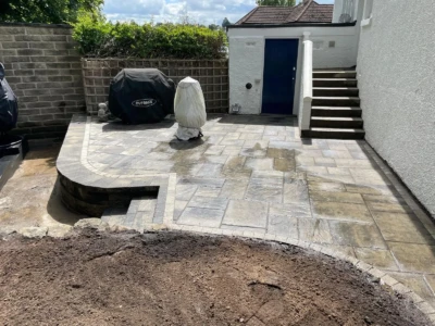 "Transform your garden into a stunning oasis with our expert Tobermore paving and retaining wall installation services in Craigleith, Edinburgh. Enhance the beauty and functionality of your outdoor space with our top-quality materials and skilled craftsmanship. Get ready to enjoy a garden makeover that will leave you in awe!" "Transformed garden in Craigleith, Edinburgh featuring Tobermore paving and a stunning Tobermore retaining wall."