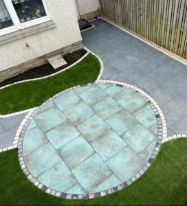 "Escape to your very own oasis with this stunning low-maintenance garden transformation in Ratho. Our team at Maybury Landscaping installed Caledonian stone verdigris porcelain paving, Sargent black paving, and artificial grass, giving this customer a beautiful and hassle-free outdoor space." "Maybury Landscaping transformed this Ratho garden with a low-maintenance design featuring Caledonian stone verdigris porcelain paving, Sargent black paving, and artificial grass."