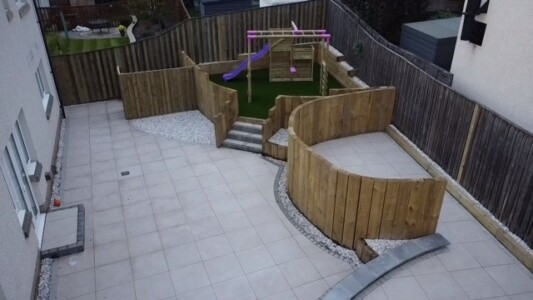 "Transforming Outdoor Spaces in Alloa! Check out our stunning porcelain patio installation, featuring vertical timber sleepers for a touch of contemporary elegance. And don't miss our vibrant artificial grass and children's play park, creating a safe and fun environment for endless adventures. Experience the beauty and functionality of our outdoor installations today!" A beautifully designed patio made from porcelain tiles, accompanied by vertical timber sleepers to create a stylish and modern outdoor space in Alloa." "A vibrant and lush artificial grass installation, perfect for a children's play park in Alloa. The artificial grass provides a safe and low-maintenance surface for kids to play on, creating a vibrant and enjoyable outdoor environment."