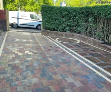 "Transforming Stevenson Drive in Edinburgh with a stunning Tobermore Heather Shannon driveway installation. The captivating pattern and rich colors of the paving stones create a visually striking entrance that adds elegance and character to the property. The meticulous craftsmanship and attention to detail are evident in every aspect of this driveway, making it a standout feature in the neighborhood. Prepare to be impressed as you step onto this exquisite driveway, a true testament to the artistry and expertise of the professionals involved." "Alt text: A visually striking Tobermore Heather Shannon driveway, expertly installed on Stevenson Drive in Edinburgh. The driveway features a beautiful arrangement of Heather Shannon paving stones, creating a captivating pattern that adds elegance and character to the entrance of the property. The deep, rich colors of the paving stones complement the surrounding landscape, while the precise installation ensures a durable and functional surface for vehicles. The attention to detail in this driveway installation showcases the craftsmanship and expertise of the professionals involved, making it a standout feature of the property."